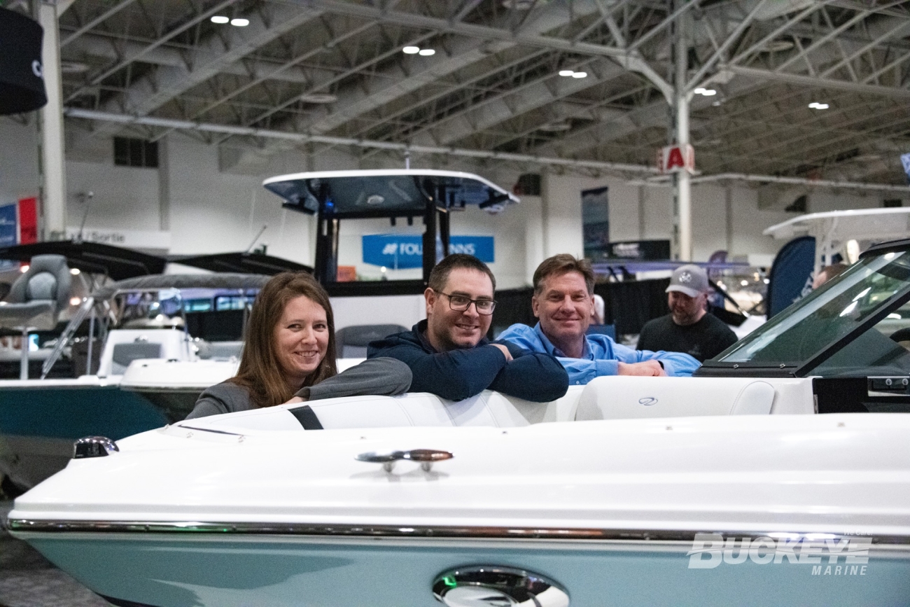 three sales people leaning on a boat