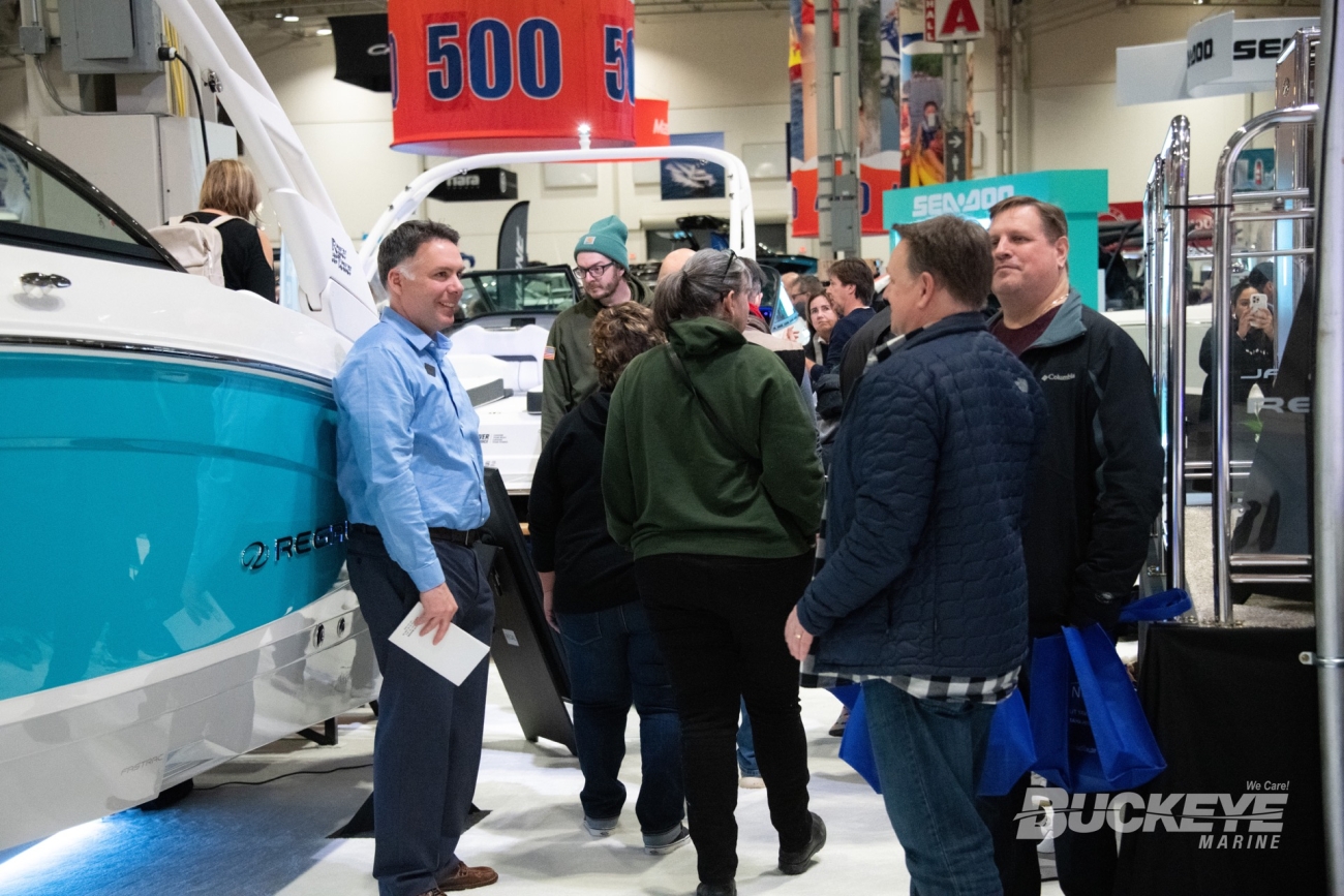 people walking around a boat show, sales man talking