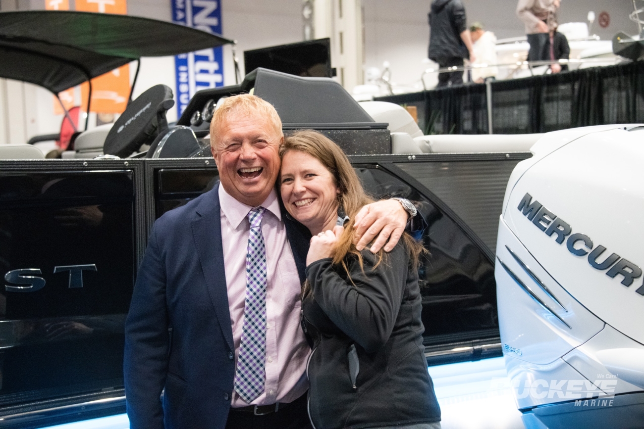 two happy sales people of buckeye marine posing in front of a boat