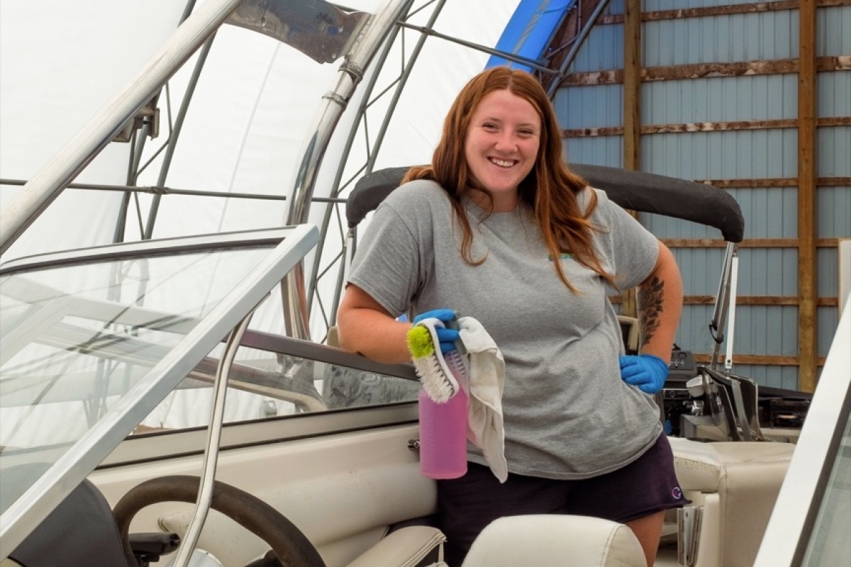 Worker posing while detailing a boat